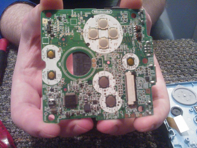 The under side of the main board showing the metal contacts for the
				buttons