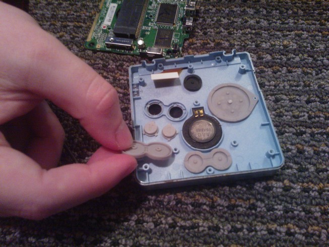 Open case revealing silicon covers over the buttons with two buttons
				removed